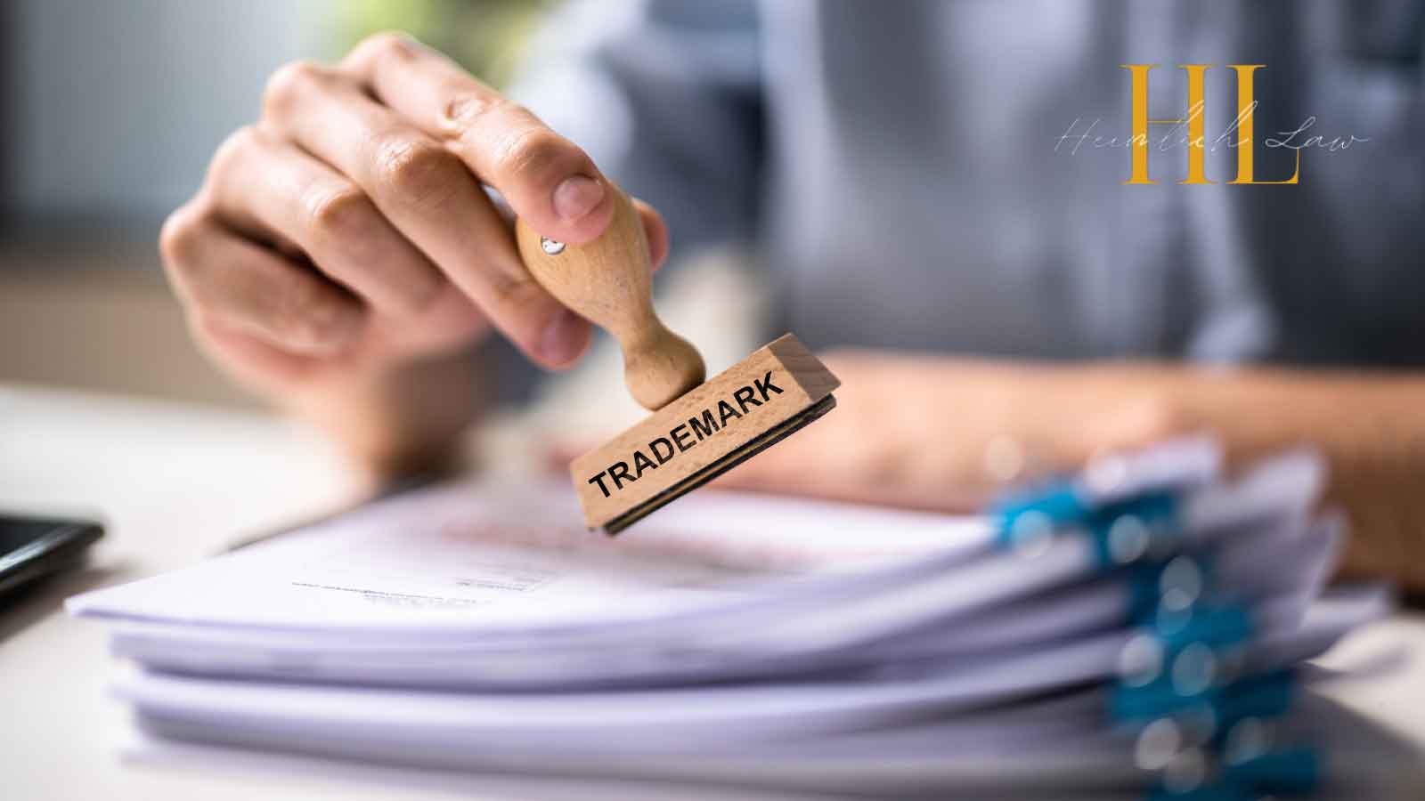 Close-up of a man’s hand stamping official papers on a desk