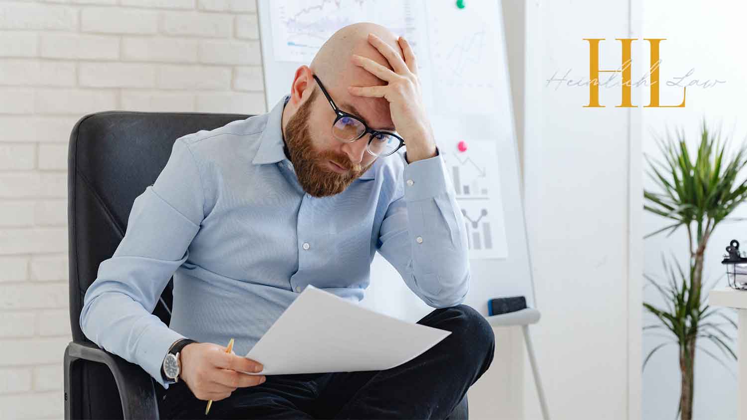 Man sitting in his office chair holding documents